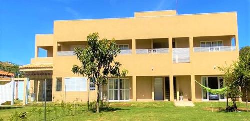 a tan building with a tree in front of it at Pousada La Belle de Jour in Chapada dos Guimarães