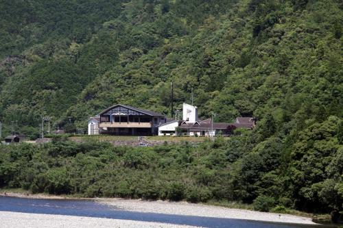 a house on a hill next to a mountain at Iruka Onsen Hotel Seiryuusou in Kumano