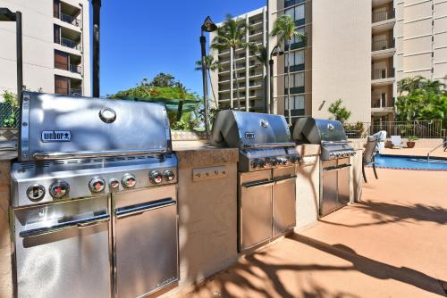 a row of stainless steel barbecue equipment in front of a pool at May on Sale! Book Now for May and SAVE BIG! in Kahana