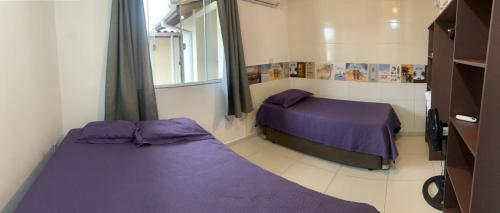 a bedroom with two beds and a window at Ocean Residence in Palhoça