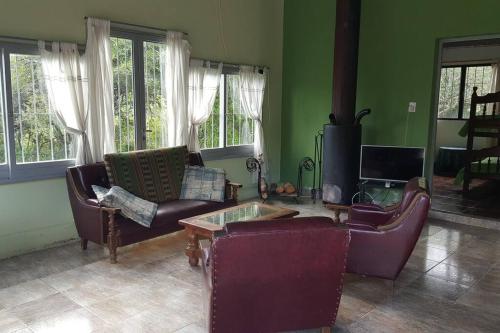 sala de estar con sofás y chimenea en Los Petti casa de campo en Salta