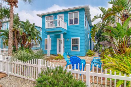 una casa azul con sillas azules frente a una valla en The Ohana Hut, en Port Aransas