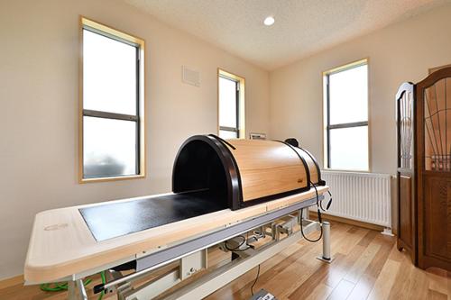 a hospital bed in a room with two windows at Hotel Takimoto in Yamanouchi