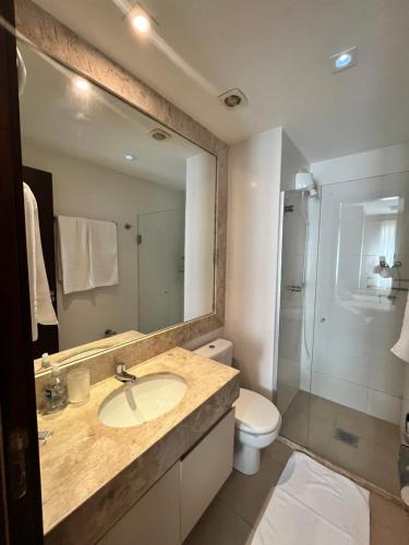 a bathroom with a sink and a toilet and a mirror at The Sun Full Condominium Resort in Brasília