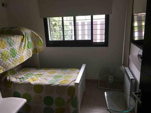 a small bedroom with a bed and a window at LA CASITA in Roldán