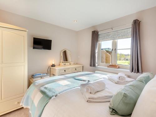 um quarto com uma cama e uma janela em Brickyard Cottage em Metheringham