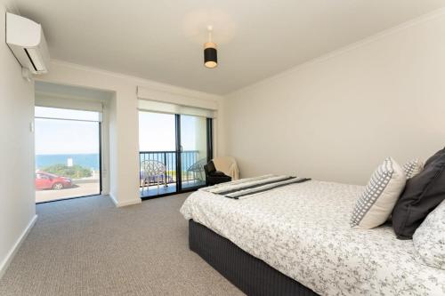 a bedroom with a bed and a view of the ocean at South Seas 5- Absolute Beachfront Wifi Views in Port Elliot