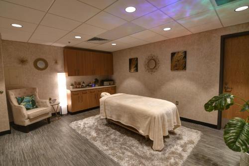 a hospital room with a bed and a chair at Oasis Hotel and Conv Center, an Ascend Collection Hotel in Springfield