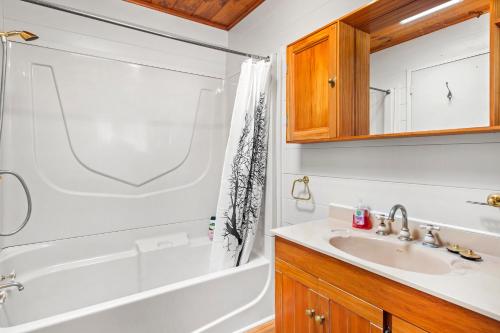 y baño con bañera blanca y lavamanos. en Bay Vista Views - Raglan Holiday Home, en Raglan