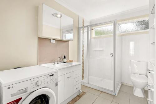 a white laundry room with a washer and dryer at Bayview Unit in Surf Beach