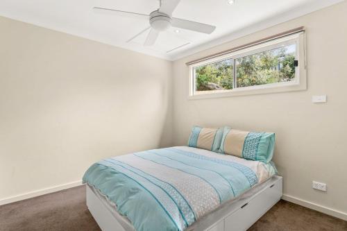 a small bedroom with a bed and a window at Bayview Unit in Surf Beach