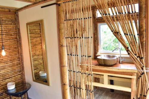 a bathroom with a sink and a wooden wall at Glamping Malu in Popayan