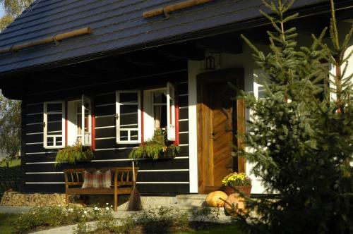 a black and white house with a porch at Penzion Roubenka in Hukvaldy