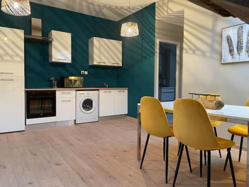 cocina con mesa de comedor y sillas amarillas en Appartement T2 tout équipé en Jujurieux