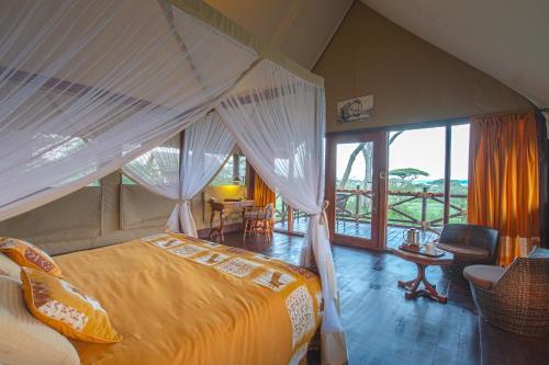 1 dormitorio con 1 cama y 1 habitación con ventana en Lake Ndutu Luxury Tented Lodge, en Sinoni