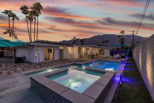 un patio trasero con piscina y una casa en The Desert Xscape Pool & Views en Palm Springs