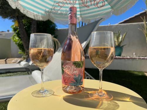 a bottle of wine sitting on a table with two glasses at Amarillo House - Luxury Home with Pool & Spa in Palm Springs