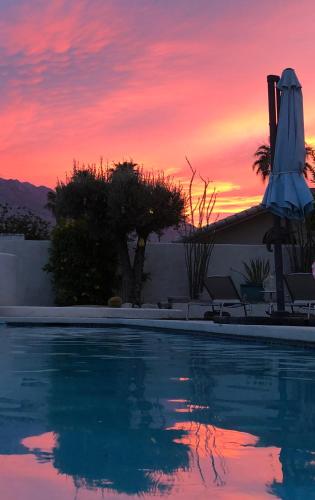 a swimming pool with a sunset in the background at Amarillo House - Luxury Home with Pool & Spa in Palm Springs