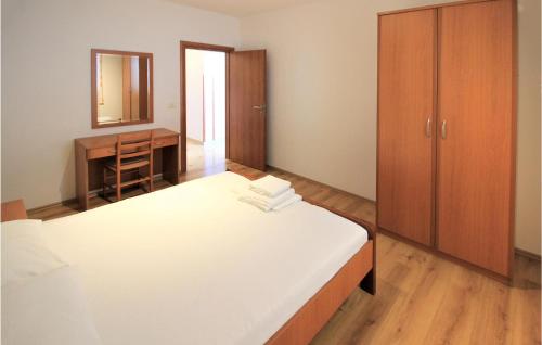 een slaapkamer met een bed, een dressoir en een spiegel bij Nice Apartment In Mandre With House Sea View in Mandre