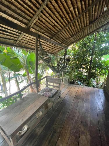 eine Holzterrasse mit einer Bank und einer Hängematte in der Unterkunft Happy Hippy House2 in Ko Chang