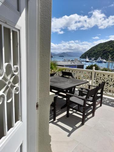 a table and chairs on a balcony with a view of the water at Oxleys 203 in Picton