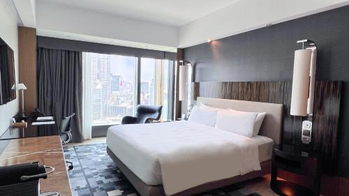 a hotel room with a bed and a large window at Hotel ICON in Hong Kong