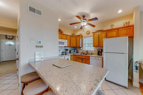 a kitchen with wooden cabinets and a white refrigerator at Hatteras Hospitality 806 #101DS-H in Hatteras