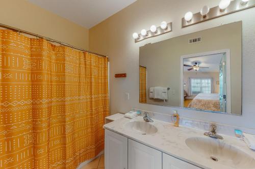 a bathroom with two sinks and a large mirror at Hatteras Hospitality 806 #101DS-H in Hatteras