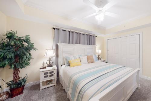 a white bedroom with a bed and a ceiling fan at Paradise Shores 107 A Slice of Paradise in Mexico Beach