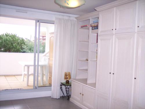 a room with white cabinets and a sliding glass door at Studio Arcachon, 1 pièce, 2 personnes - FR-1-319-42 in Arcachon