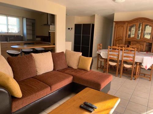 un salon avec un canapé et une salle à manger dans l'établissement Maison Confortable avec Clim, Terrasse et Jardin - 6 Pers, Proche Lac et Plages - FR-1-319-425, à Parentis-en-Born