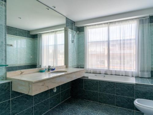 La salle de bains est pourvue d'un lavabo, d'une baignoire et d'une fenêtre. dans l'établissement Arcachon: T3 lumineux avec parking privé, accès plage, wifi - FR-1-319-461, à Arcachon