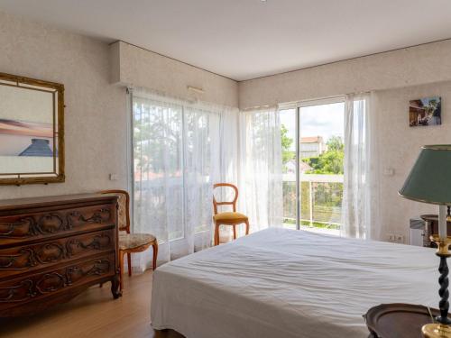 une chambre avec un lit, une commode et une fenêtre dans l'établissement Arcachon: T3 lumineux avec parking privé, accès plage, wifi - FR-1-319-461, à Arcachon