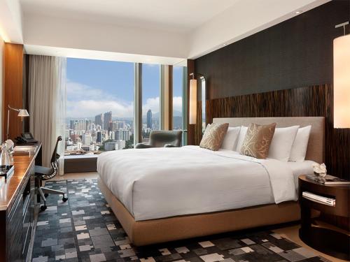 a hotel room with a bed and a desk and a window at Hotel ICON in Hong Kong