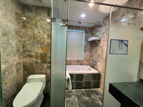 a bathroom with a toilet and a bath tub at HANA Stay Riverside in Hanoi
