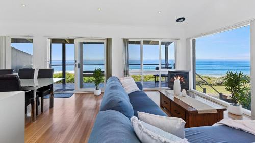 a living room with a blue couch and a view of the ocean at 5 Whitecrest Great Ocean Road Resort - Ocean Views in Apollo Bay