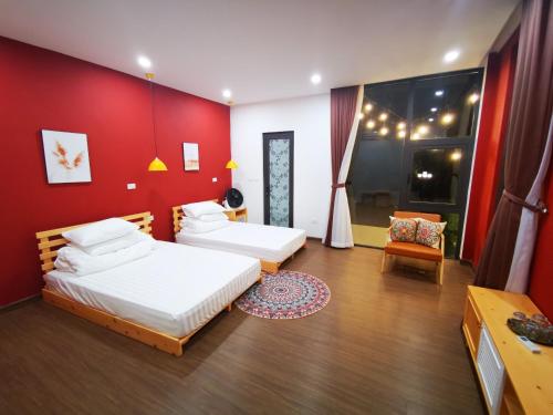 a bedroom with two beds and a red wall at Hannah Villa Ba Vi - Venuestay in Ba Vì