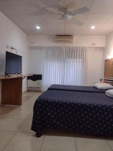 a bedroom with a bed and a television in it at Studio Estrada Escobar in Belén de Escobar
