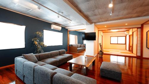 a living room with a couch and a coffee table at 琉球モダン宿りゅうだん in Naha