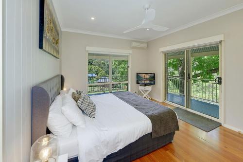 um quarto com uma cama grande e janelas em The Acreage Boutique Guesthouse em North Avoca