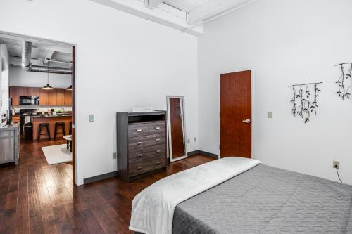 a bedroom with a large bed and a kitchen at NY Style Centric Loft with King Bed by Park ave in Rochester