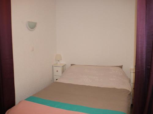 une petite chambre avec un lit et une table de chevet dans l'établissement Biscarrosse Plage - Studio T1 Bis en Bord de Mer - Ménage Inclus - FR-1-319-185, à Biscarrosse-Plage