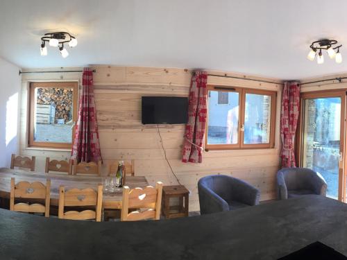 une salle à manger avec une table, des chaises et une télévision dans l'établissement Appartement spacieux pour 8 personnes à Val Cenis Lanslevillard, proche des pistes et commodités - FR-1-508-38, à Lanslebourg-Mont-Cenis