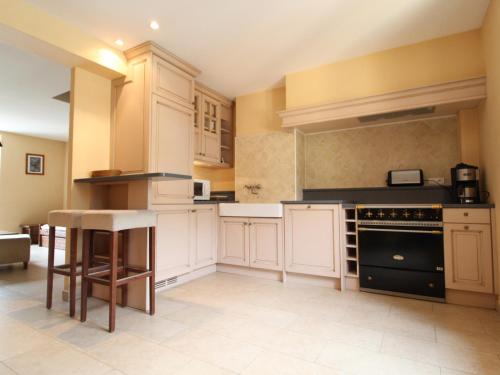 une grande cuisine avec des placards blancs et un four noir dans l'établissement Spacieux duplex 10 pers à Lanslebourg avec cheminée, WIFI, 4 chambres - FR-1-508-43, à Lanslebourg-Mont-Cenis