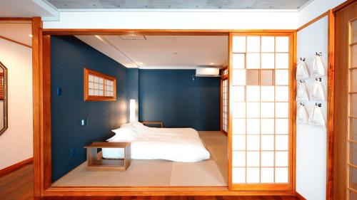那覇市にある琉球モダン宿りゅうだんの青い壁のベッドルーム1室(ベッド1台付)