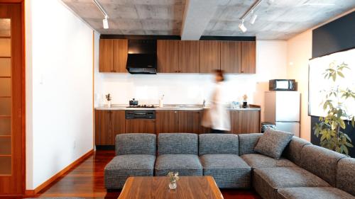 a living room with a couch and a table at 琉球モダン宿りゅうだん in Naha