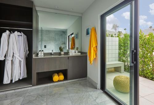 a bathroom with a sink and a mirror at Twin Palms Resort - A Gay Men's Resort in Palm Springs