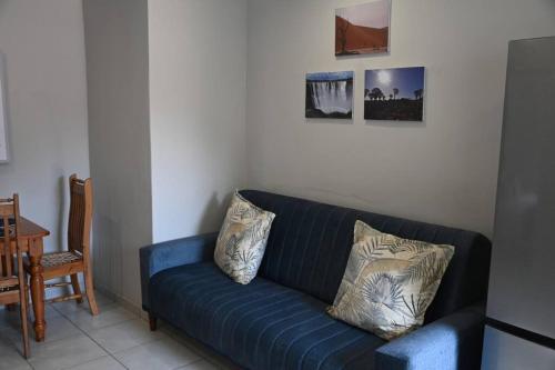 a blue couch in a living room with two pillows at Montaña Casita - A comfortable and central cottage in Pretoria