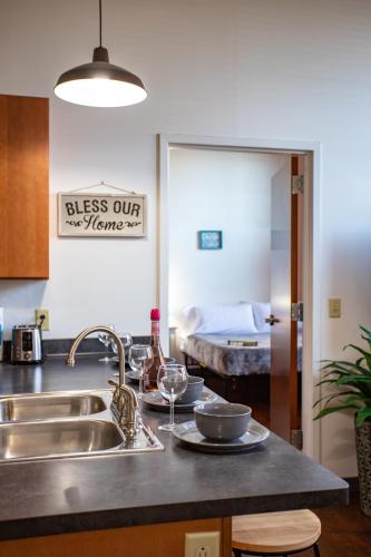 a kitchen counter with a sink and a bed in the background at NY Style Centric Loft with King Bed by Park ave in Rochester