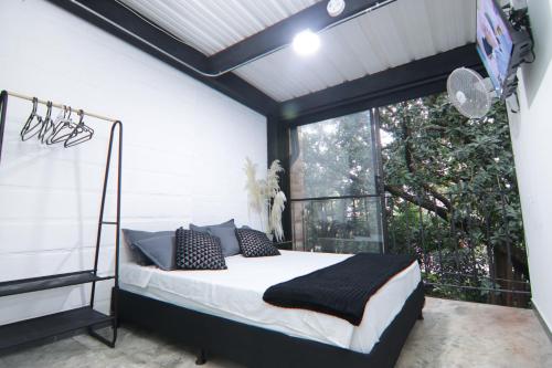 ein Schlafzimmer mit einem Bett und einem großen Fenster in der Unterkunft Hotel Casa Malibú in Medellín